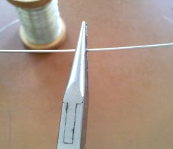 copper wire held by pliers